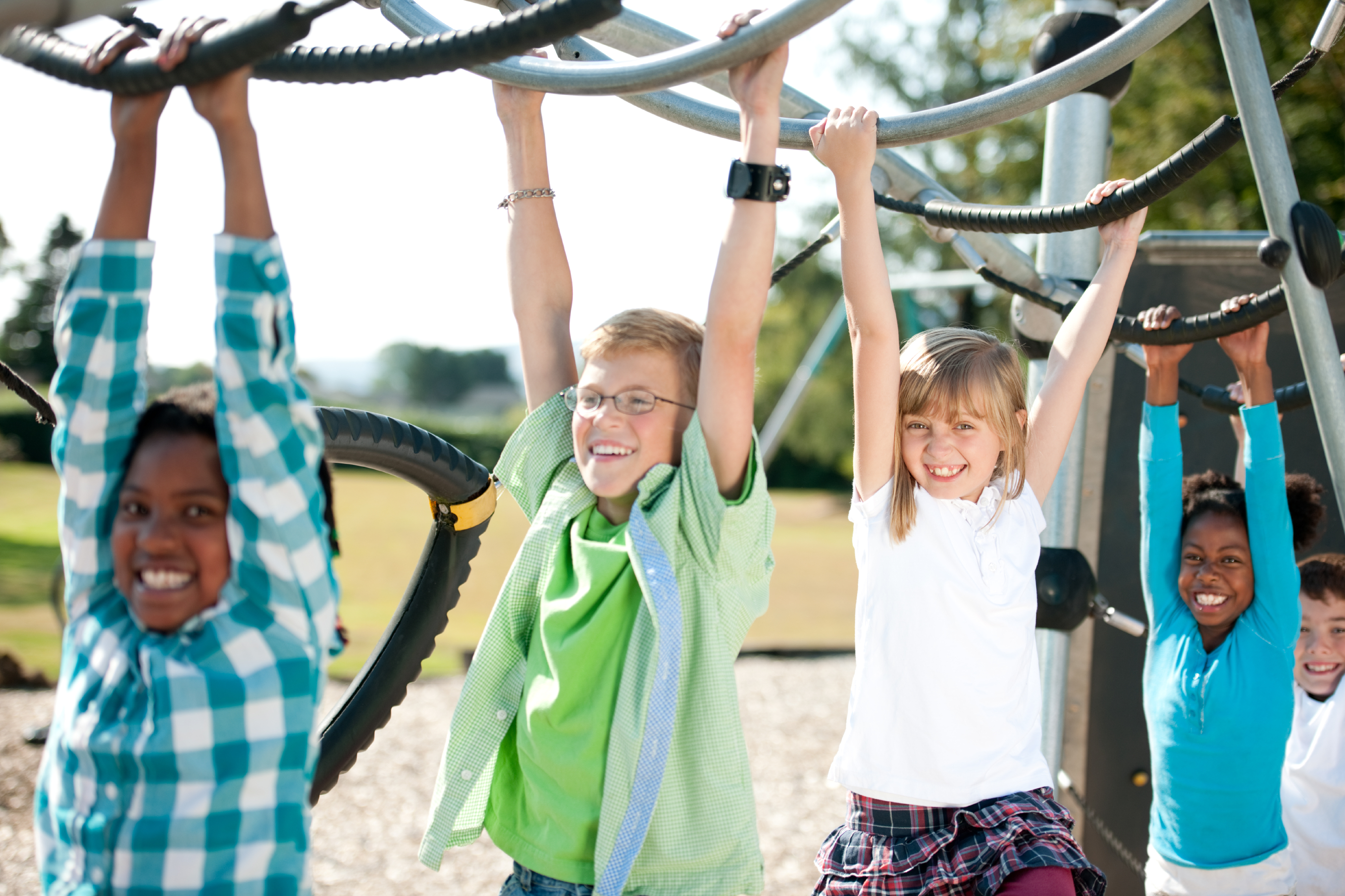 Four children grab bars on jungle gym