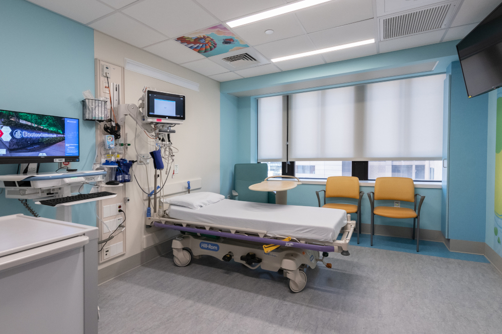 Hospital room with bed, medical equipment, and two chairs
