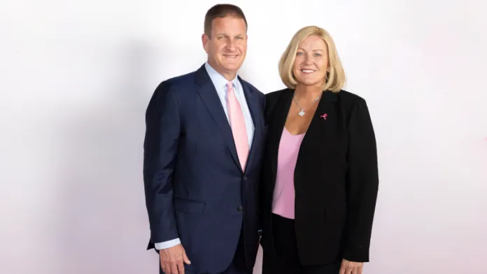Man wearing suit and tie and woman wearing business suit pose for portrait