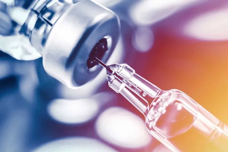 Image of a syringe inserted into a vial of medication