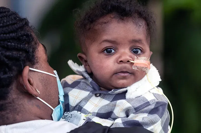 a boy being held by his mom