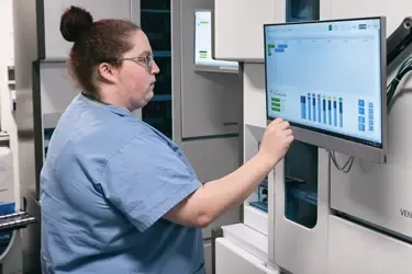 Woman in scrubs checking health information on a computer screen