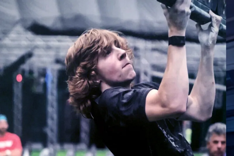 Teen boy holds onto ninja bar