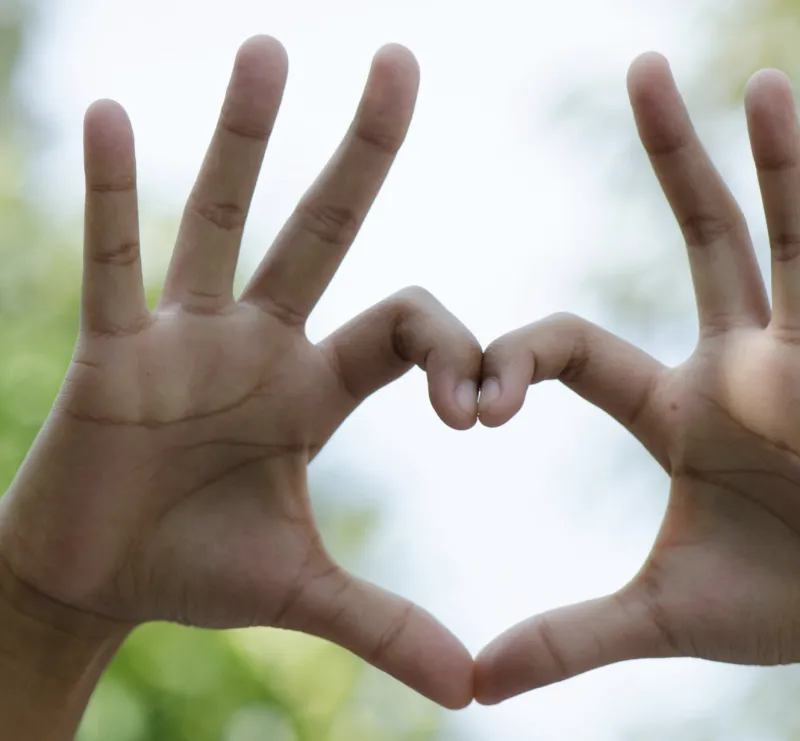Thumbs and pointing fingers held together in the shape of a heart