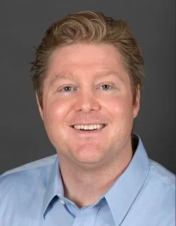Headshot of a red headed man, Michael Silver, who smiles at the camera for his photo.