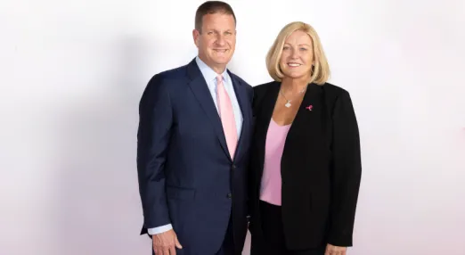 Man wearing suit and tie and woman wearing business suit pose for portrait