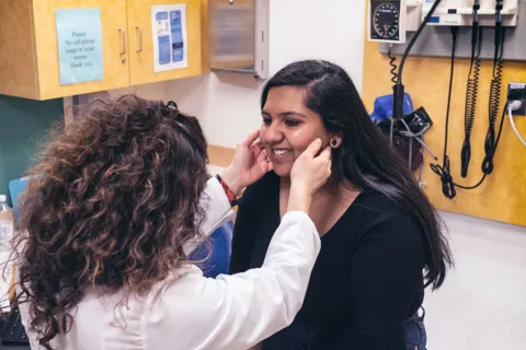 Female clinician feels woman's lymph nodes