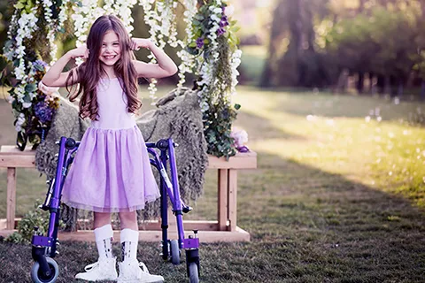 Girl wearing shirt and sleeveless shirt while standing outside flexes arms for camera